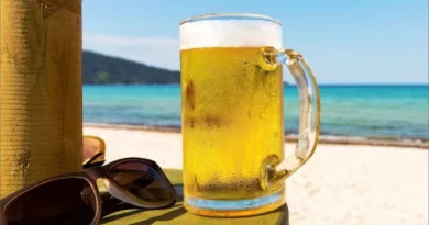 Birra d'estate con spiaggia in sottofondo