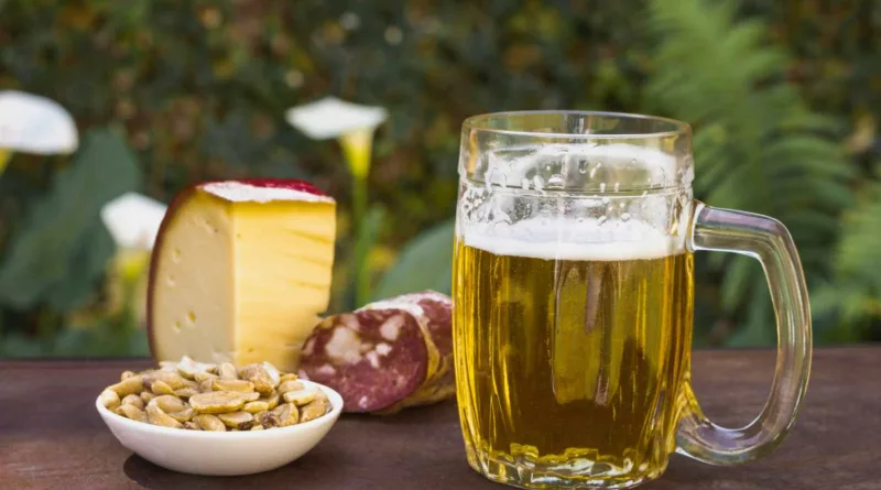 Boccale di birra con salame, formazzio e snacks