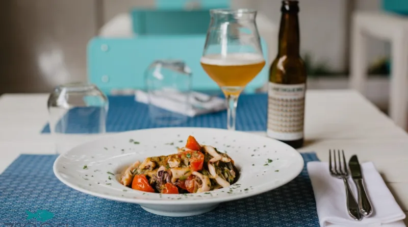 Piatto di pesce con calice di birra al ristorante 7 Scogli